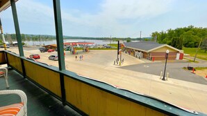 A view from a window overlooking a parking lot with a gas station and a building with a red roof.
