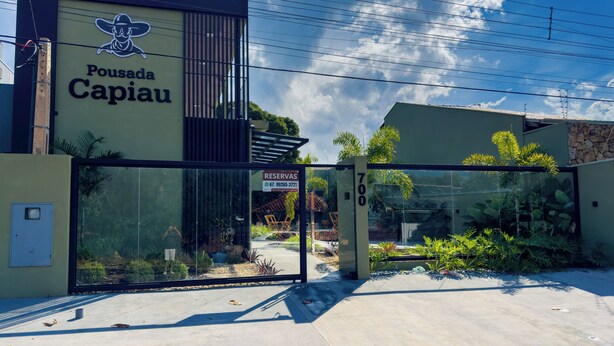 A building with a sign reading "Pousada Capiau" and a glass door entrance. - Pousada Capiau  (Bonito)