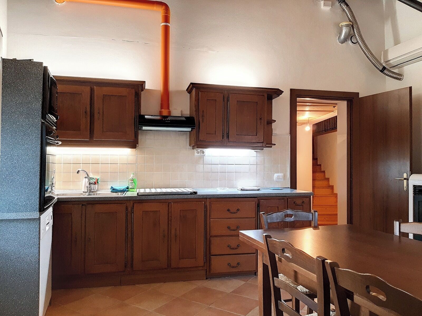 Una cocina con armarios de madera, una encimera y una estufa.