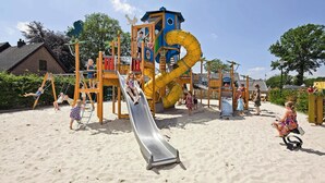 A playground with a slide, swings, and climbing structures. - Wander Lodge | 5 persons (Voorthuizen)