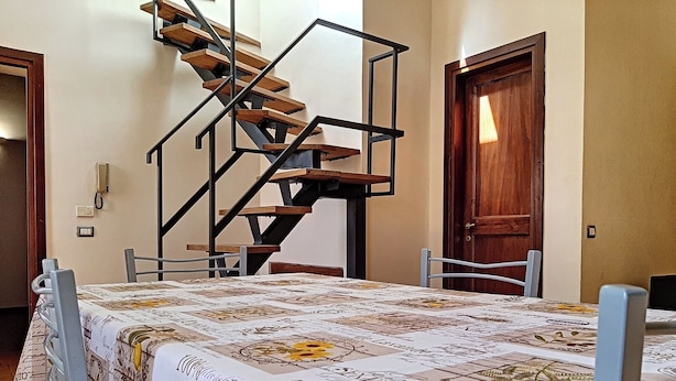 A bedroom with a bed, a wooden staircase, and two doors.