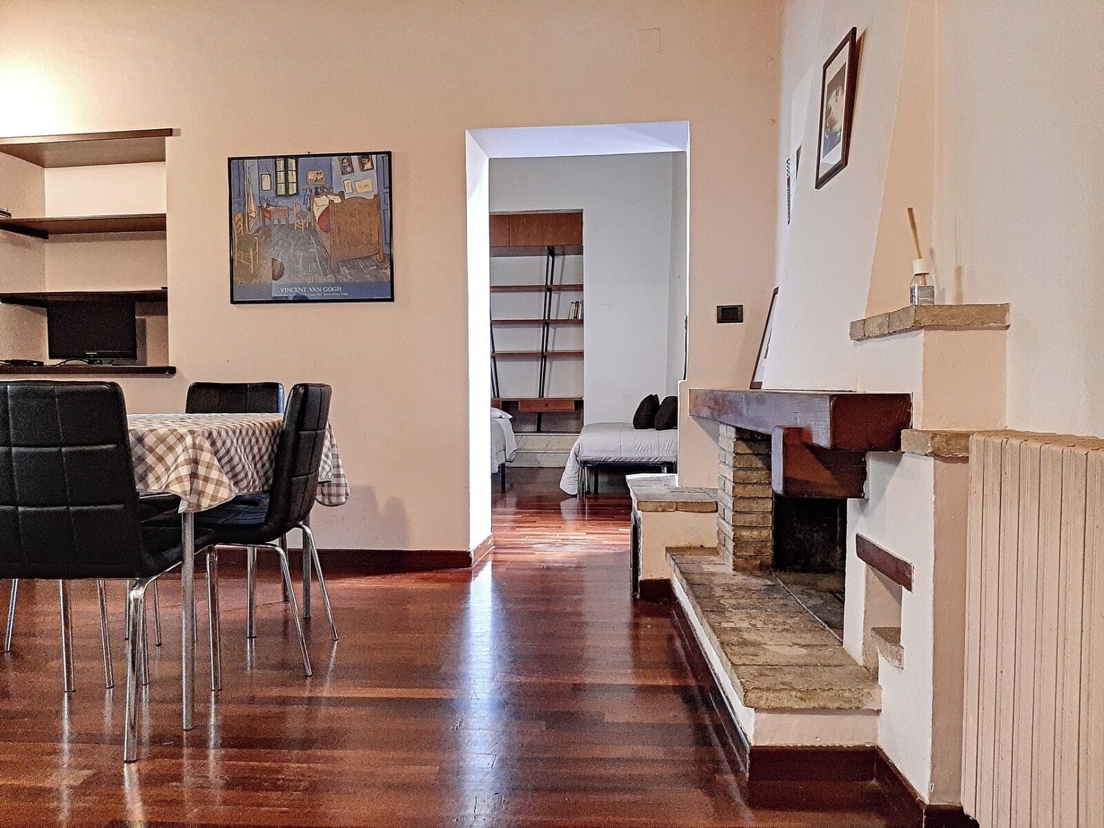 Ein Wohnzimmer mit Essbereich, Kamin und Bücherregal.
