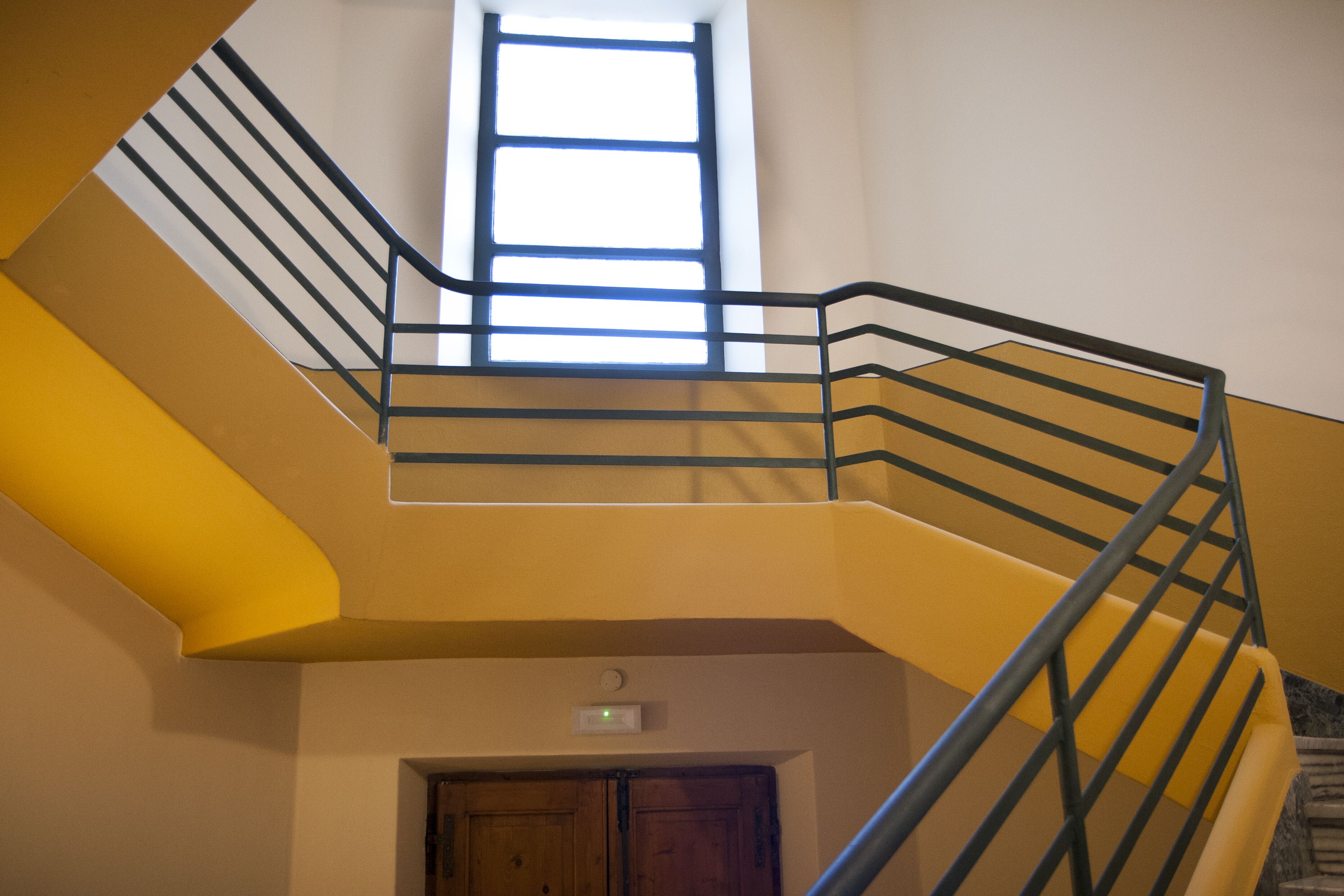 A multi-level interior with a staircase, a window, and a door.