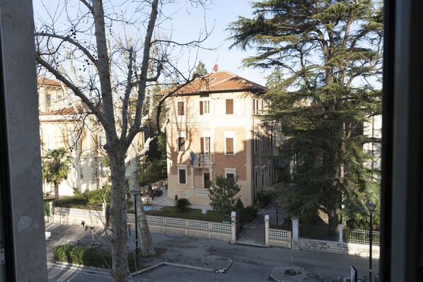 Un edificio a più piani con facciata in mattoni, diverse finestre e un piccolo balcone.