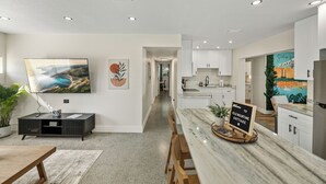 A modern kitchen with white cabinets, a marble countertop, and a sign that reads "Welcome to CLEMENTINE COTTAGE." - Family-Friendly 3BR | Downtown & Lake Hollingsworth (Lakeland)