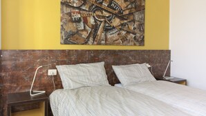 Ein Schlafzimmer mit einem Bett, zwei Nachttischen, einem Wandbild und einem Holzkopfstück.