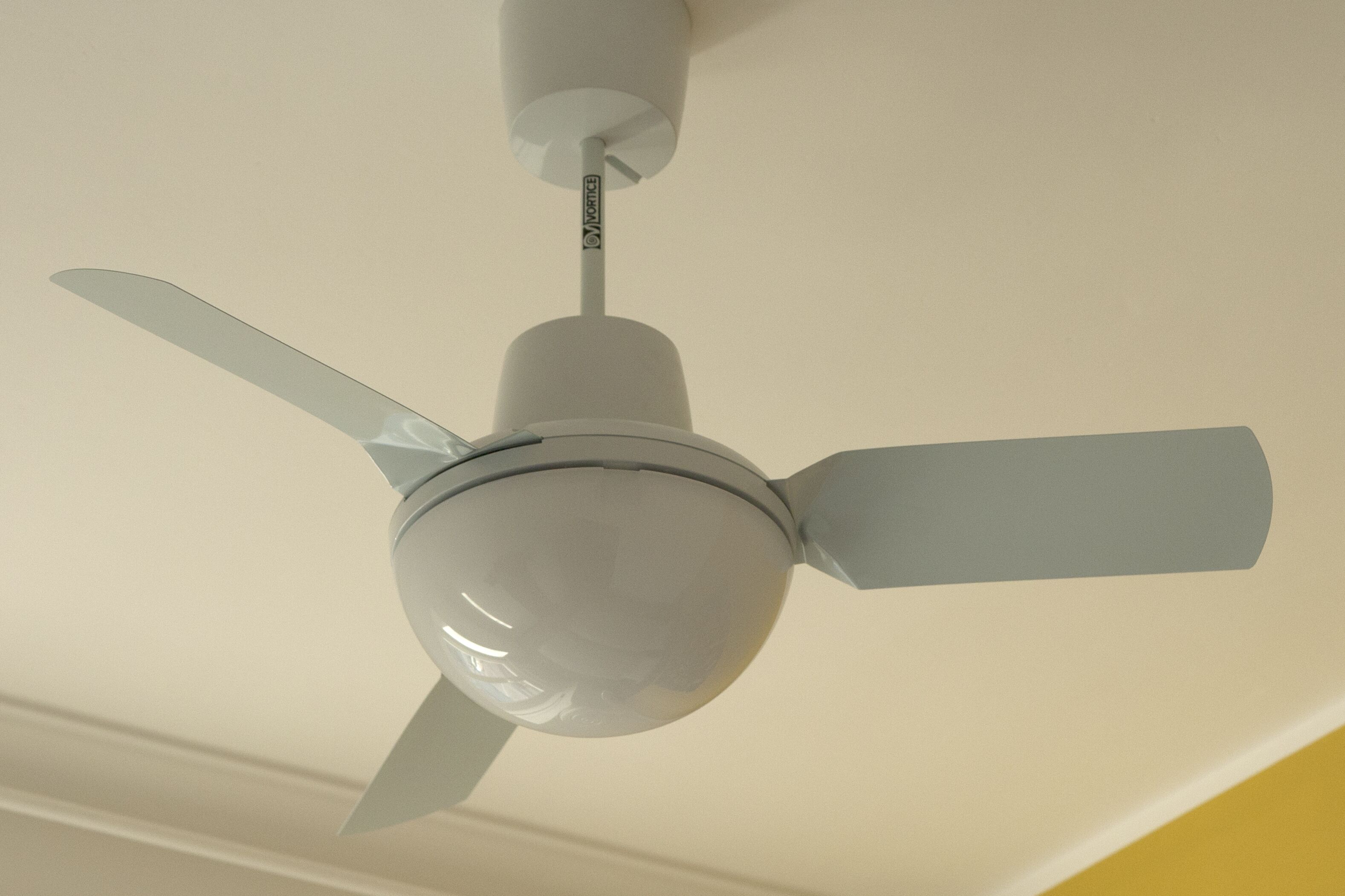 A ceiling fan with three blades and a central light fixture.