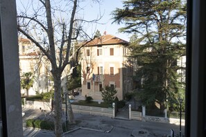 Ein mehrstöckiges Gebäude mit Ziegelverkleidung, zahlreichen Fenstern und einem kleinen Balkon.