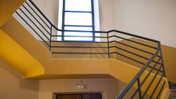 Un interno su più livelli, con una scala, una finestra e una porta.