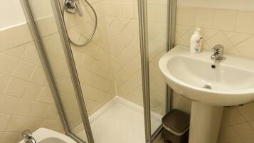 A bathroom with a shower, toilet, and sink.