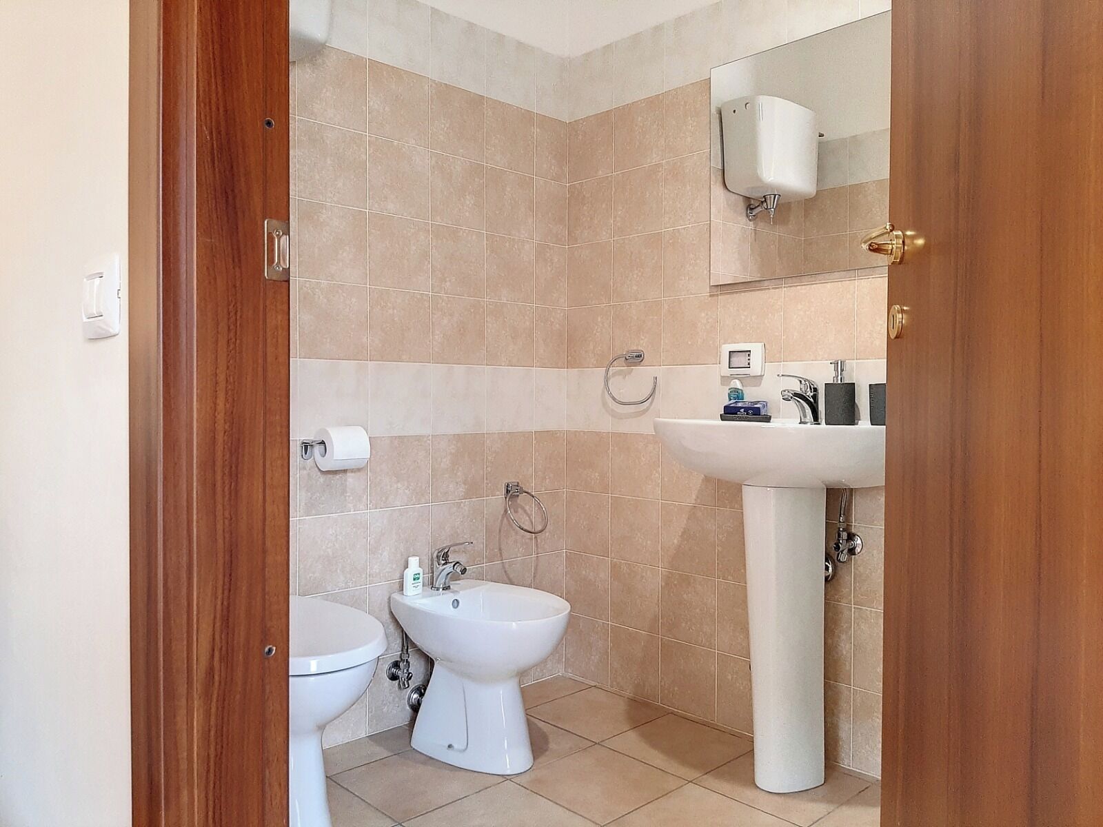 A bathroom with a toilet, bidet, and sink.