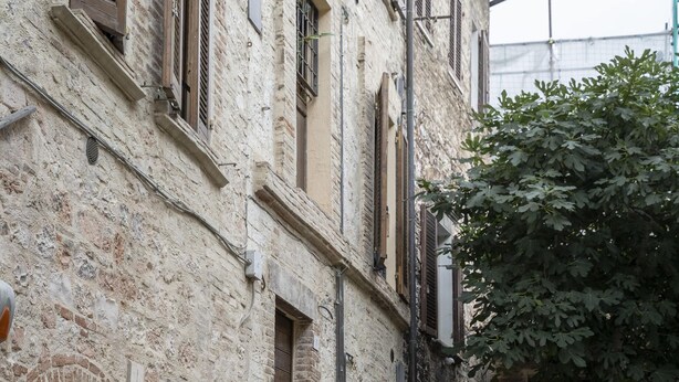 Un bâtiment étroit en pierre, avec un escalier menant à un niveau supérieur.