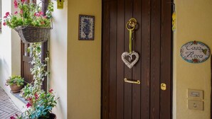 Een houten deur met een hartvormige decoratie, een sleutel en een bordje met de tekst 'Casa Flora'.