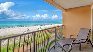 Un balcon avec vue sur une plage et l’océan.