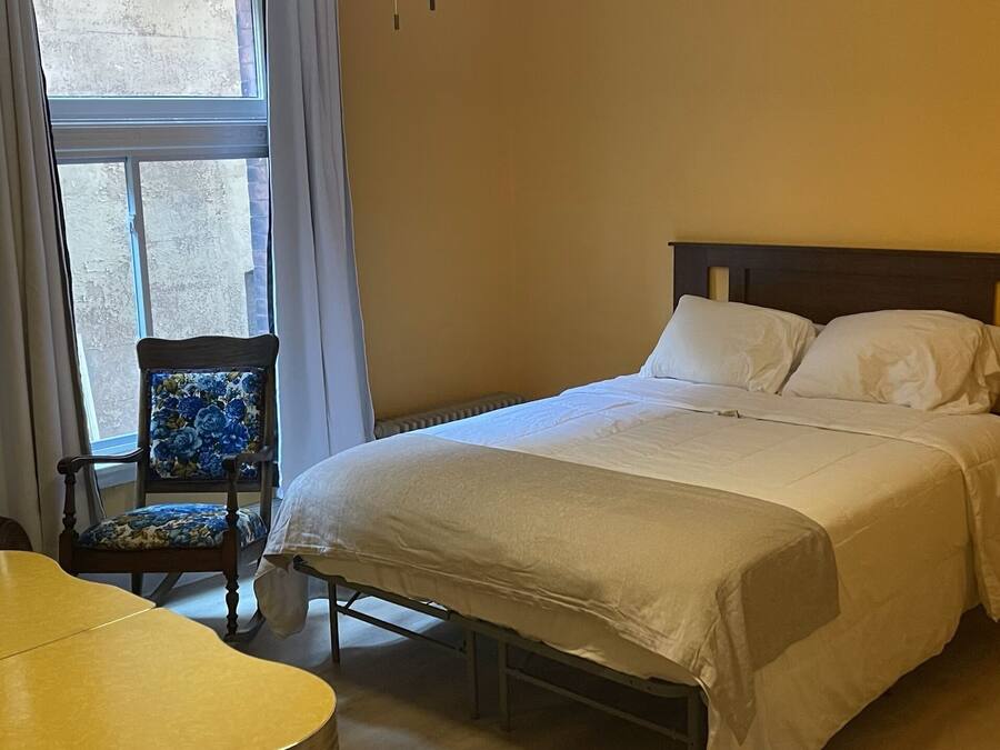 Une chambre à coucher avec un lit, une chaise et une table.