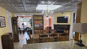 A spacious living area with a granite island, wooden chairs, a fireplace, and a television. - Buffalo Guesthouse (Buffalo)