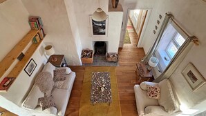 Ein gemütliches Wohnzimmer mit Kamin, einer Couch, einem Couchtisch und einem Bücherregal.