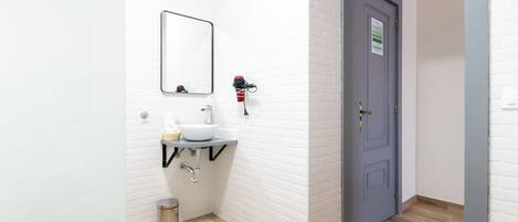 A modern bathroom with a white bathtub, a sink, and a mirror.