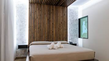 Un dormitorio moderno con techo de listones de madera, cama con plataforma gris, pared de mármol y una silueta enmarcada en la pared.
