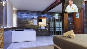 Een moderne badkamer met een ruime badkuip, een spiegel en een douchehoek.