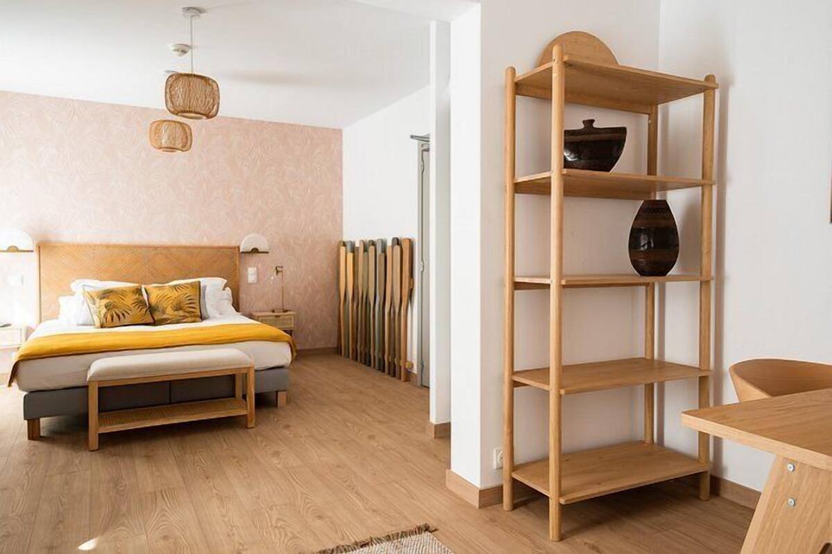 Ein modernes Schlafzimmer mit einem Holzbett, einer Holzregaleinheit und einem Holztisch.