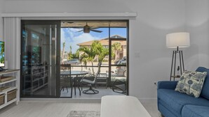 A modern living room with a sliding glass door leading to a patio area.