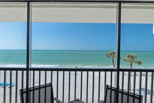 Een balkon met uitzicht op het strand en de oceaan.