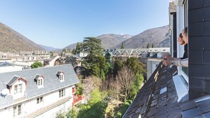 Un edificio residencial con techo inclinado, una antena parabólica y vistas a un paisaje montañoso.