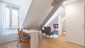 Una cocina moderna con encimera blanca, sillas de madera y una mesa de comedor.