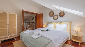 Un dormitorio con cama, mesitas de noche, armario y barra de desayuno.