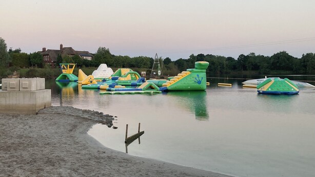 An outdoor water play area with various inflatable structures.