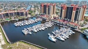 Un port de plaisance où sont amarrés de nombreux bateaux, entouré d’immeubles de grande hauteur coiffés de toits rouges.