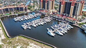 Un port de plaisance où de nombreux bateaux sont amarrés, entouré d’immeubles de grande hauteur.