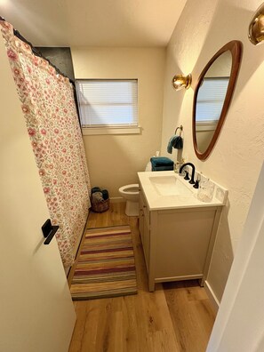 Enjoy a refreshing shower in this bathroom, featuring a shower, sink, and mirror.