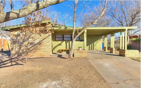 Guests can relax on the covered porch with a bench and potted plant.