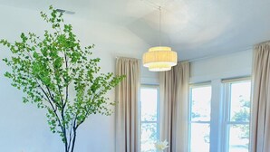 Een moderne keuken met een centraal eiland, donkere kastjes en een groot raam dat voor natuurlijk licht zorgt.
