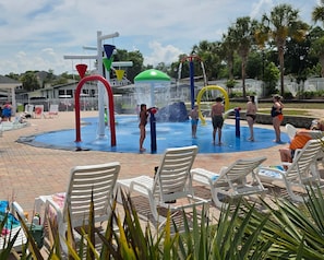 A water park with a water play area, lounge chairs, and a pool. - NEW! Coastal Camelot - Walk to Surfside Beach (Surfside Beach)