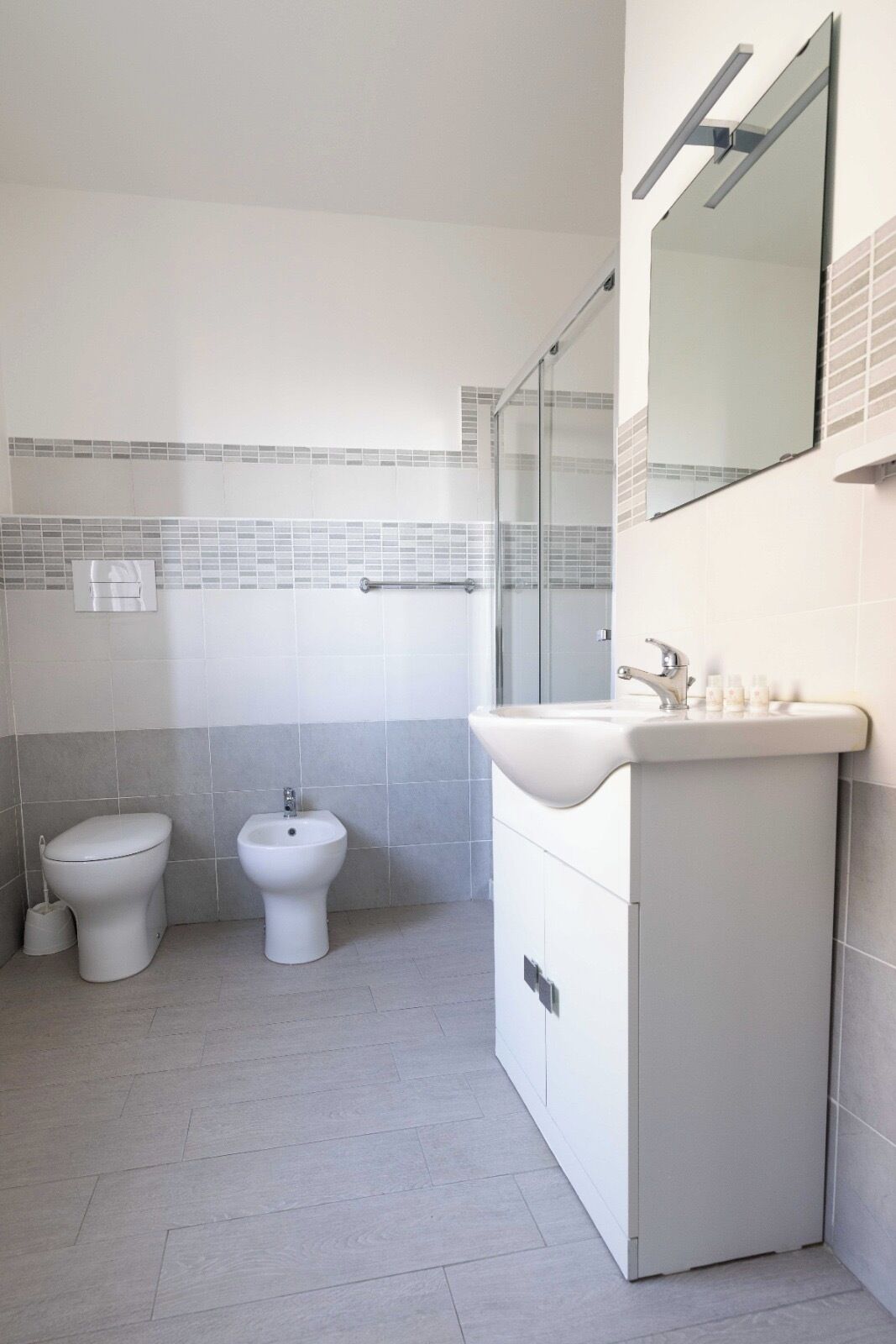 A bathroom with a toilet, bidet, and sink.