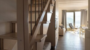 Ein modernes Interieur mit einer Holztreppe, die zu einem Balkon führt.