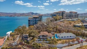 Una propiedad costera con varias construcciones, piscina y vistas al mar y a las montañas.