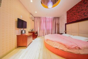 A hotel room with a bed, a desk, a television, and a window with curtains. - 998 Business Hostel (Hai'an)
