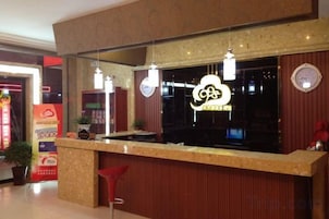 Una recepción con un letrero de neón, un espejo arriba y una silla roja.