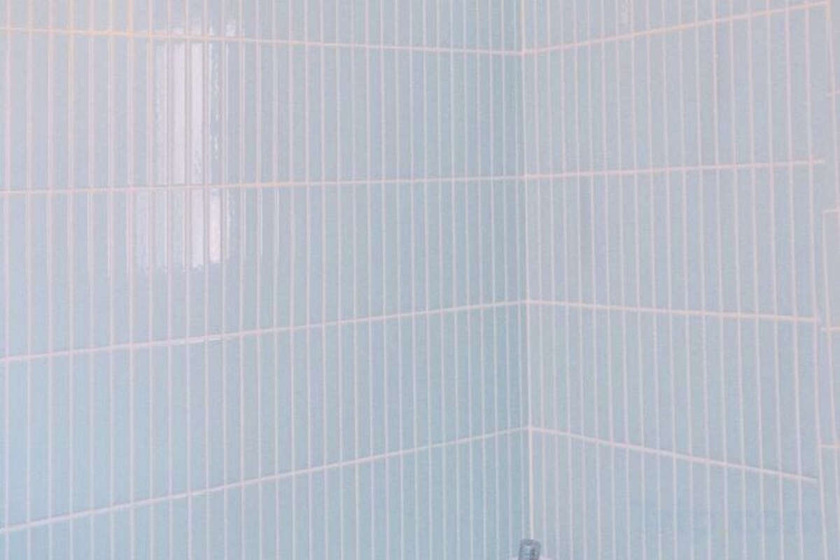 A room with a grid-like pattern on the wall, a window, and a door.
