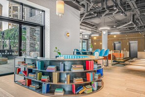 Cozy reading nook with a curved bookshelf and comfortable seating areas.