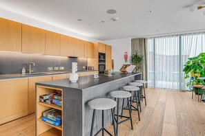 Enjoy dining and socializing at the kitchen island with bar stools, overlooking the city view.