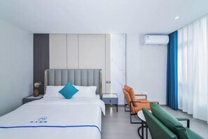A modern hotel room with a bed, a nightstand, a chair, and a desk. - Dali Yuji Courtyard (Dali City)
