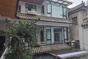 A two-story building with a balcony, large windows, and a traditional tiled roof. - Dali Yuji Courtyard (Dali City)