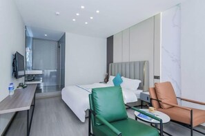 Una habitación de hotel moderna con una cama, un escritorio, una silla y un televisor.