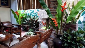 Un rincón interior acogedor con muebles de madera y varias plantas en macetas.