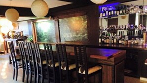 Una zona de bar con sillas de madera y una barra.